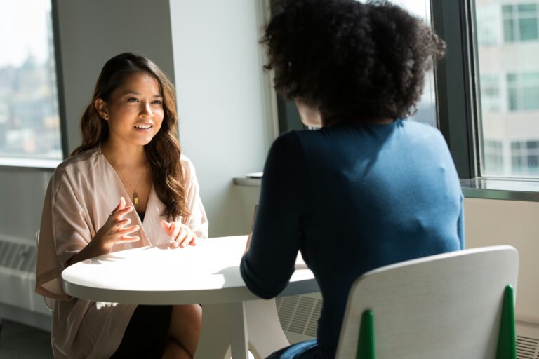 job candidate at desk asking conulstant how to find a recruiter