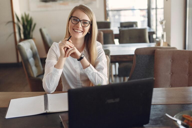 smiling woman at her desk who works for an accounting and finance recruitment agency