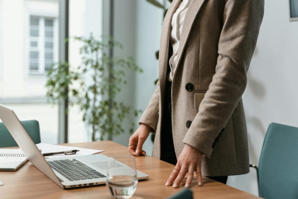 cropped woman in a leadership role standing up at her desk