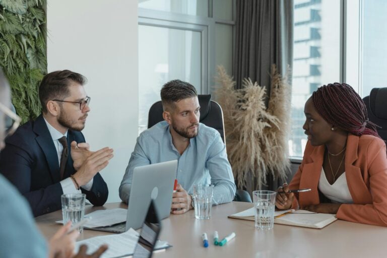 three hiring managers discussing finance recruitment agencies at a table